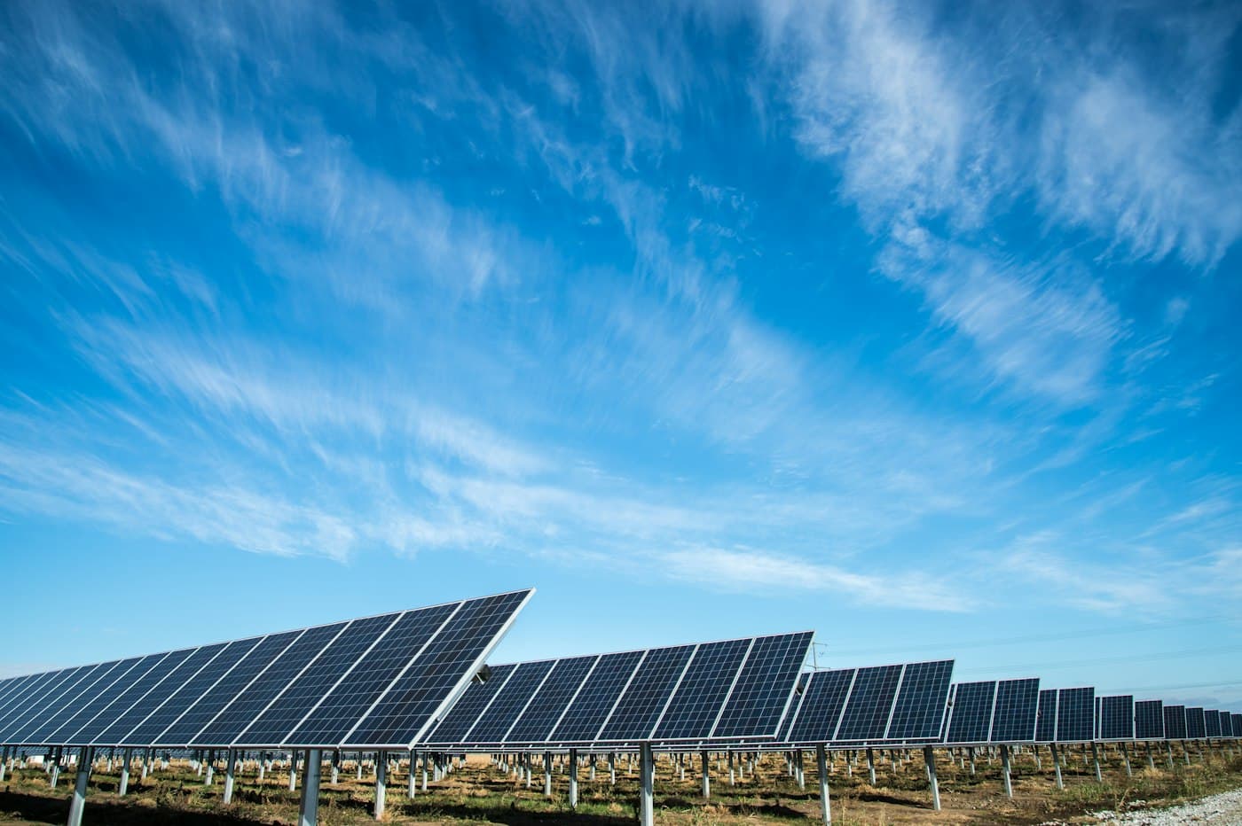 Deretan panel surya di bawah langit biru